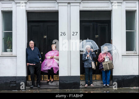 London, UK.  31 August 2015.  Couples take shelter from the rain as they watch day two of Notting Hill Carnival in west London. Credit:  Stephen Chung / Alamy Live News Stock Photo