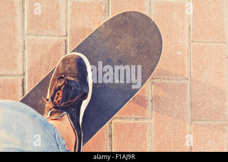 Skateboard view from abowe with foot in sneakers on Stock Photo