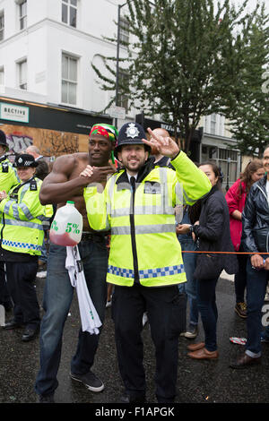 Notting Hill, UK. 31st August, 2015. A partygoer and police officer at the Notting Hill carnival. Credit:  Keith Larby/Alamy Live News Stock Photo