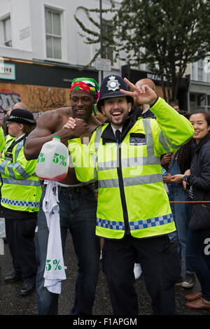 Notting Hill, UK. 31st August, 2015. A partygoer and police officer at the Notting Hill carnival. Credit:  Keith Larby/Alamy Live News Stock Photo