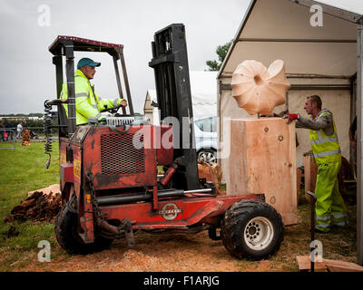 Cheshire, UK. 31st Aug, 2015. Two men and a forklift truck carry an exhibit at the The 11th English Open Chainsaw Carving Competition held at the Cheshire Game and Country Show at the Cheshire County Showground Credit:  John Hopkins/Alamy Live News Stock Photo