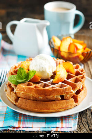 Belgian waffles with ice cream and fresh peaches Stock Photo