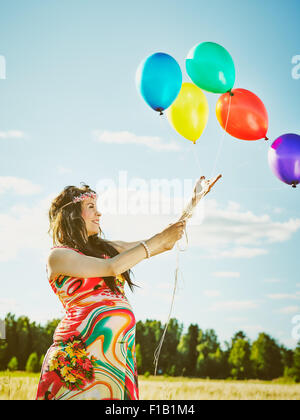 Beautiful pregnant young woman feeling lovely and relax outdoors and she plays with a balloons Stock Photo