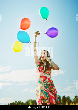 Beautiful pregnant young woman feeling lovely and relax outdoors and she plays with a balloons Stock Photo