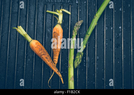 Carrot and asparagus on black metal background grill Stock Photo
