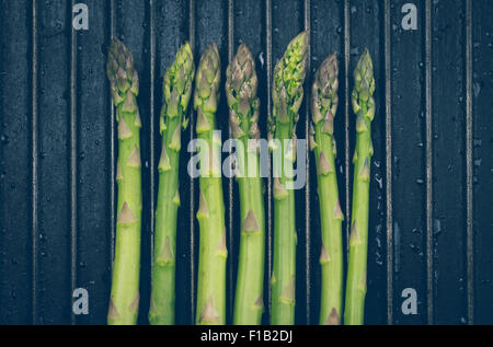 Bunch of asparagus on black metal background grill Stock Photo