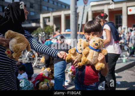 Munich, Germany. 1st Sep, 2015. A refugee child is happy about some donated plushies, at Munich's central train station, in Munich, Germany, 1 September 2015. PHOTO: NICOLAS ARMER/dpa/Alamy Live News Stock Photo