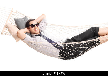 Carefree young businessman lying in a hammock and looking at the camera isolated on white background Stock Photo