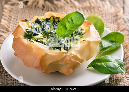 Spinach pie on white plate, close up view Stock Photo