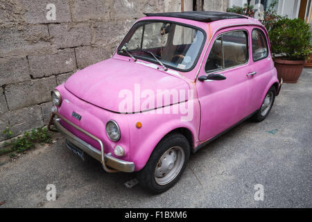 Lacco Ameno, Italy - August 15, 2015: Old pink Fiat Nuova 500 city car produced by the Italian manufacturer Fiat between 1957 an Stock Photo