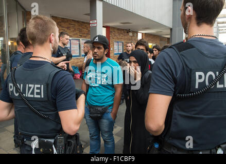 Munich, Germany. 1st Sep, 2015. Policemen speak to people who arrived by train from Hungary via Austria, and try to find refugees among them, at Munich's central train station, in Munich, Germany, 1 September 2015. PHOTO: PETER KNEFFEL/dpa/Alamy Live News Stock Photo