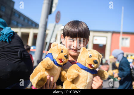 Munich, Germany. 1st Sep, 2015. A refugee child is pleased with donated toys at the central train station in Munich, Germany, 1 September 2015. Photo: Nicolas Armer/dpa/Alamy Live News Stock Photo