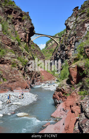 Couple and their young daughter hiking at the bottom of the Daluis Gorge toward a bridge 80-meter-high above the Var River. Alpes-Maritimes, France Stock Photo