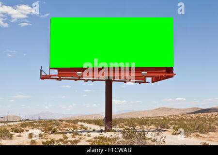 Blank billboard with chroma key green in the middle of the Mojave desert. Stock Photo