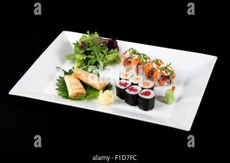 menu of sushi and roll fish with vegetables and wasabi on white plate, on black Stock Photo
