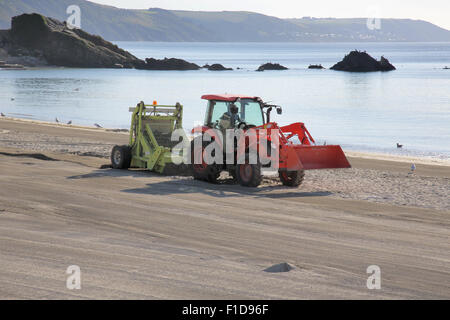 cleaning the beach at looe on the south cornwall coast Stock Photo