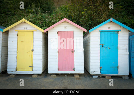 Three beach huts in pastel colours at Shanklin on the Isle of Wight UK Stock Photo