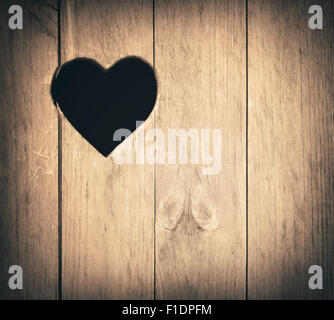 Heart shape cut on wooden wall, toilet, wc door or window Stock Photo