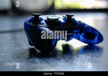 Blue transparent game conroller on blue surface Stock Photo