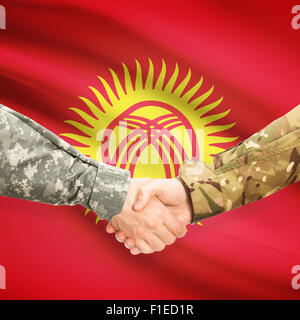 Soldiers shaking hands with flag on background - Kyrgyzstan Stock Photo