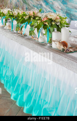 Beautiful bouquets and decorations on table in wedding hall. Stock Photo