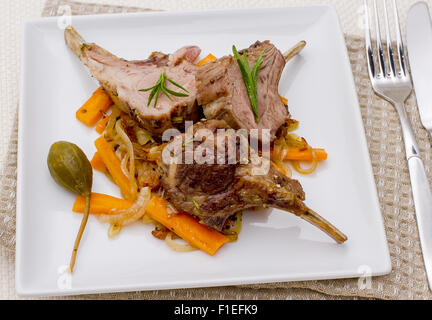 Grilled racks of lamb with onion, garlic and capers, top view Stock Photo