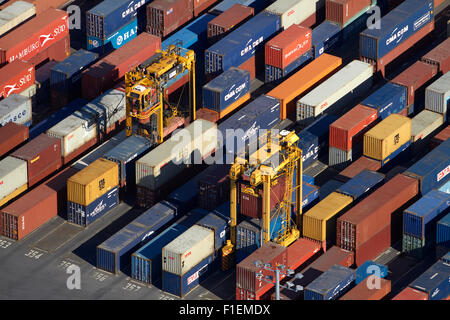 Straddle cranes and containers at Ports of Auckland, Auckland, North Island, New Zealand - aerial Stock Photo