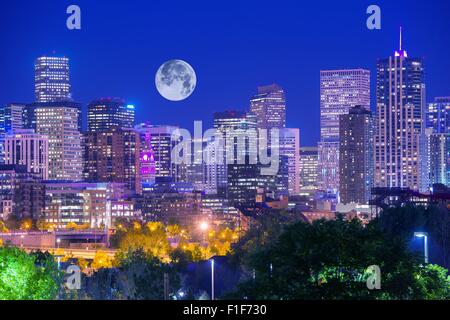 Denver Colorado at Night. Denver Downtown Skyline and the Full Moon on Clear Sky. Stock Photo