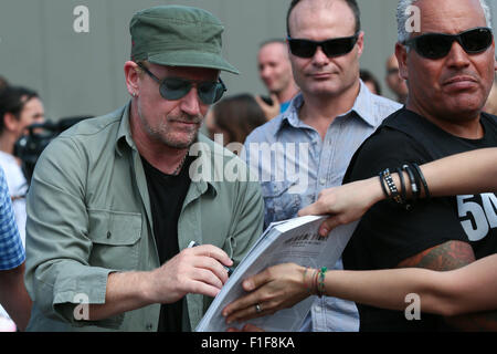 Turin, Italy. 01st Sep, 2015. Bono signs an autograph. Bono Vox, the frontman of the Irish rock band U2 arrives at the Olympic Stadium where hundreds of their fans wait for press conference and autograph signing. Credit:  Elena Aquila/Pacific Press/Alamy Live News Stock Photo