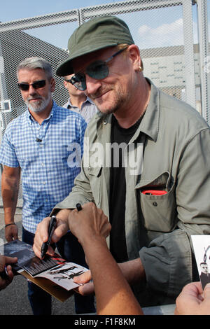 Turin, Italy. 01st Sep, 2015. Bono signs autograph. Bono Vox, the frontman of the Irish rock band U2 arrives at the Olympic Stadium where hundreds of their fans wait for press conference and autograph signing. Credit:  Elena Aquila/Pacific Press/Alamy Live News Stock Photo