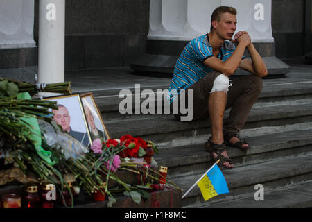 Kiev, Ukraine. 01st Sep, 2015. Young injured soldier sits near the place of fatal occasion as Ukrainians place flowers in commemoration of Igor Debrin (24) and Dmytro Slastikov (21), a Ukrainian National Guard soldiers who was fatally wounded during clashes between protesters and police, in front of Parliament. Ukrainian policemen were killed in clashes with protesters outside the parliament in Kiev on 31 August the interior minister said, after a vote on changing Ukrainian Constitution about decentralization. © Sergii Kharchenko/Pacific Press/Alamy Live News Stock Photo