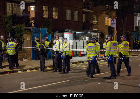 London, UK. 31 August, 2015. Metropolitan Police Officers wearing riot gear at the scene of a stabbing on the corner of Ladbroke Grove and Elgin Crescent after the Notting Hill Carnival 2015. Credit:  Pete Maclaine/Alamy Live News Stock Photo