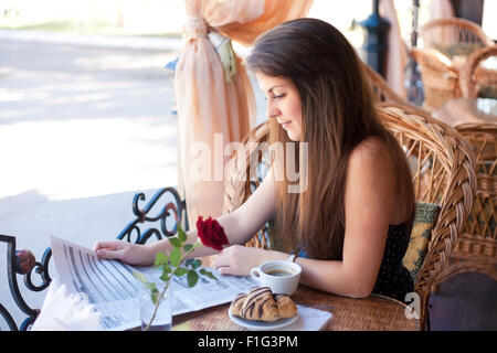 Young beautiful woman newspaper   in the cafe Stock Photo