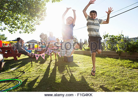 Portrait playful boys jumping for joy sunny park