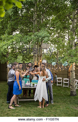 Bride, groom and wedding guests toasting wine reception