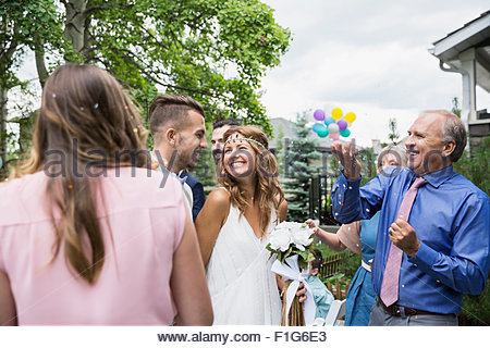 Wedding guests throwing confetti over bride and groom