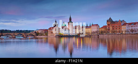 Prague. Panoramic image of Prague riverside and Charles Bridge, with reflection of the city in Vltava River. Stock Photo