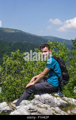 Happy teenage boy posing on the edge of a very high cliff Stock Photo