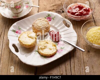 Afternoon tea of with fresh baked scones with jam and clotted cream Stock Photo