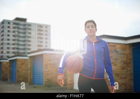 Portrait of mature female basketball player holding ball Stock Photo