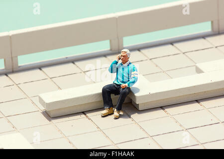 Miniature old man talking on the Cell phone Stock Photo