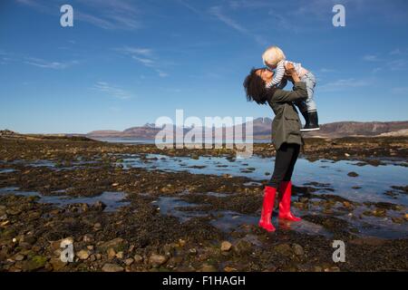 Mother holding son by Loch Eishort, Isle of Skye, Hebrides, Scotland Stock Photo