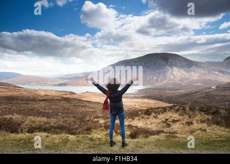 Mid adult woman in mountains with arms up, Isle of Skye, Hebrides, Scotland Stock Photo