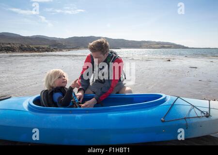 Father helping son in canoe, Loch Eishort, Isle of Skye, Hebrides, Scotland Stock Photo