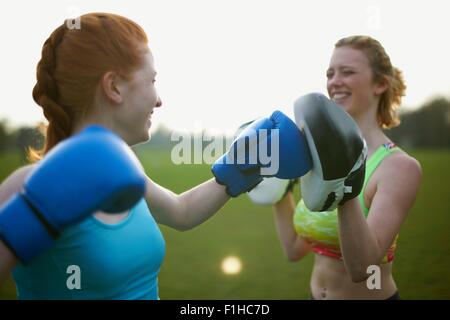 Two women exercising with boxing gloves in the park Two women exercising with boxing gloves in the park