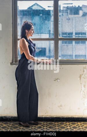 Mid adult woman looking out of window Stock Photo