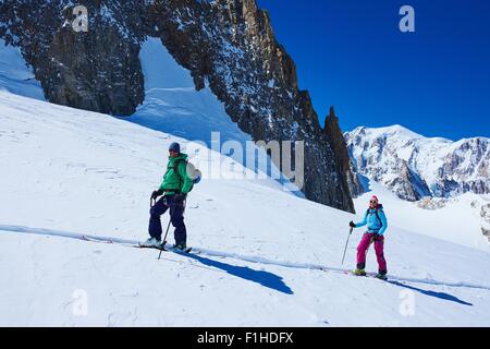 Mature male and female skiers moving up Mont Blanc massif, Graian Alps, France Stock Photo