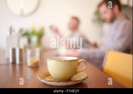 Cup on table and people in background in a cafe Stock Photo