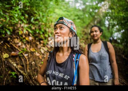 Two young women tourists strolling in jungle at Manoa Falls, Oahu, Hawaii, USA Stock Photo