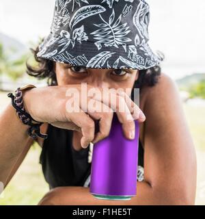 Close up portrait of young man wearing sunhat drinking from can Stock Photo